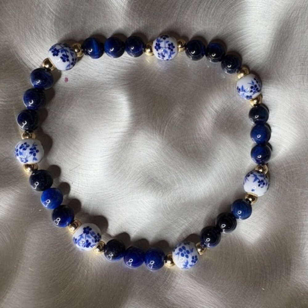 bracelet features deep navy blue gemstone beads and white porcelain-style beads